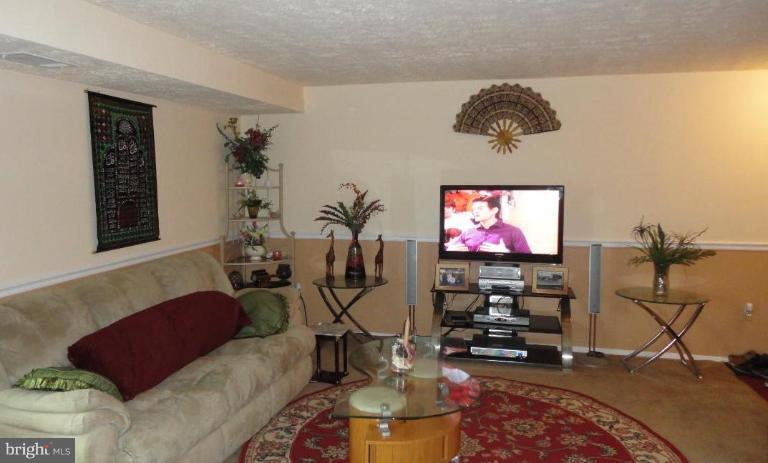 19517 Gunners Branch Road, Unit 432 Germantown, MD 20876 - Photo 6 of 6 a living room with furniture and a flat screen tv