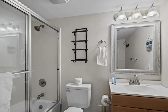 a bathroom with a sink a toilet and shower