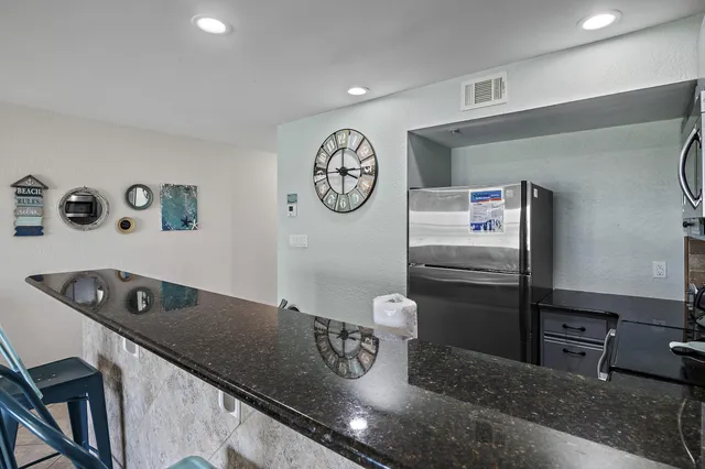 a kitchen with stainless steel appliances granite countertop a sink a stove and a refrigerator