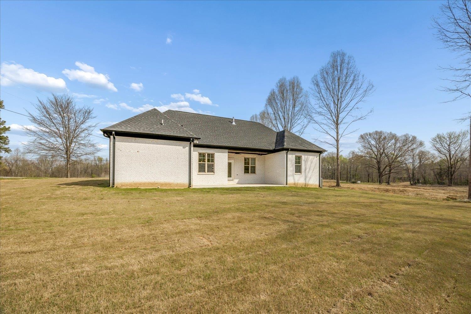 2939 Brighton-Clopton Road Brighton, TN 38011 - Photo 31 of 36 Rear view of property with a yard, a patio area, roof with shingles, and brick siding