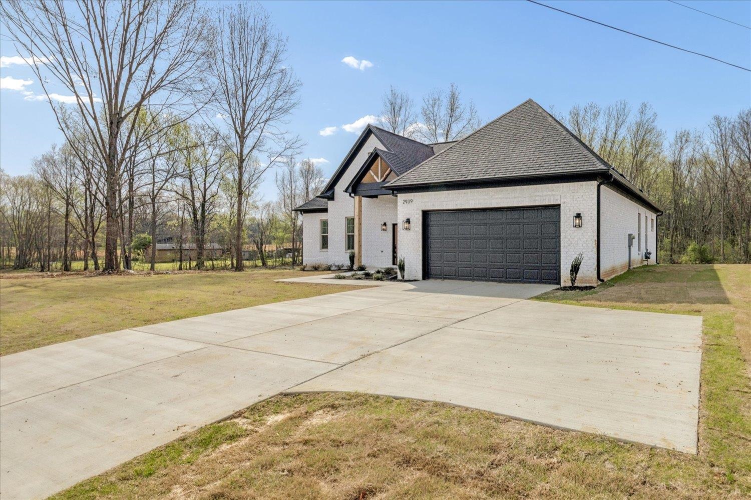 2939 Brighton-Clopton Road Brighton, TN 38011 - Photo 32 of 36 View of front of home featuring an attached garage, brick siding, a front yard, and concrete driveway