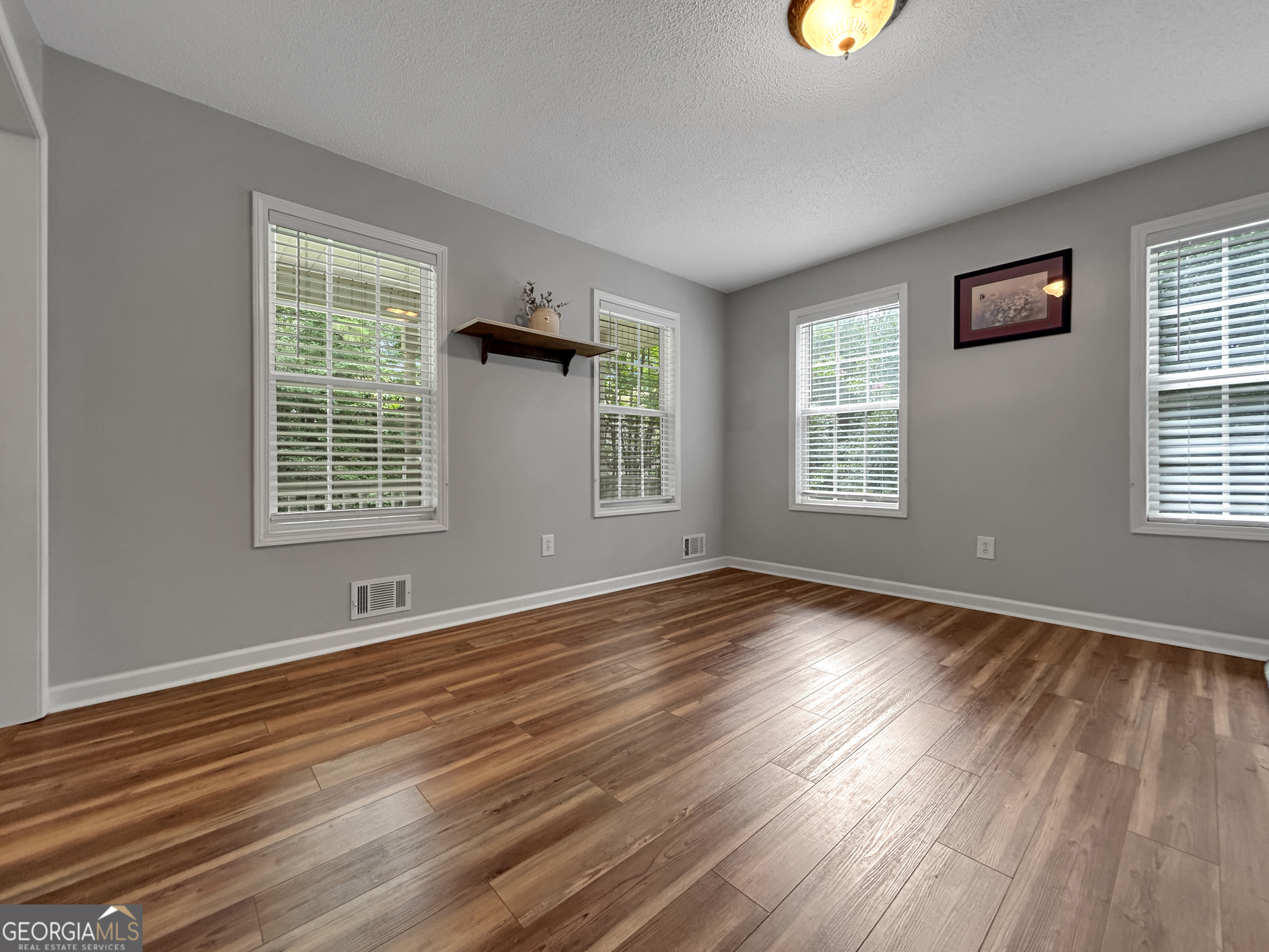 715 Frog Road Locust Grove, GA 30248 - Photo 9 of 56 a view of an empty room with wooden floor and a window