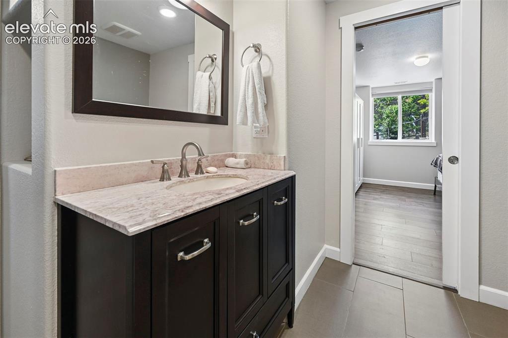 10643 Pictured Rocks Drive Peyton, CO 80831 - Photo 24 of 37 a bathroom with a granite countertop sink and a mirror