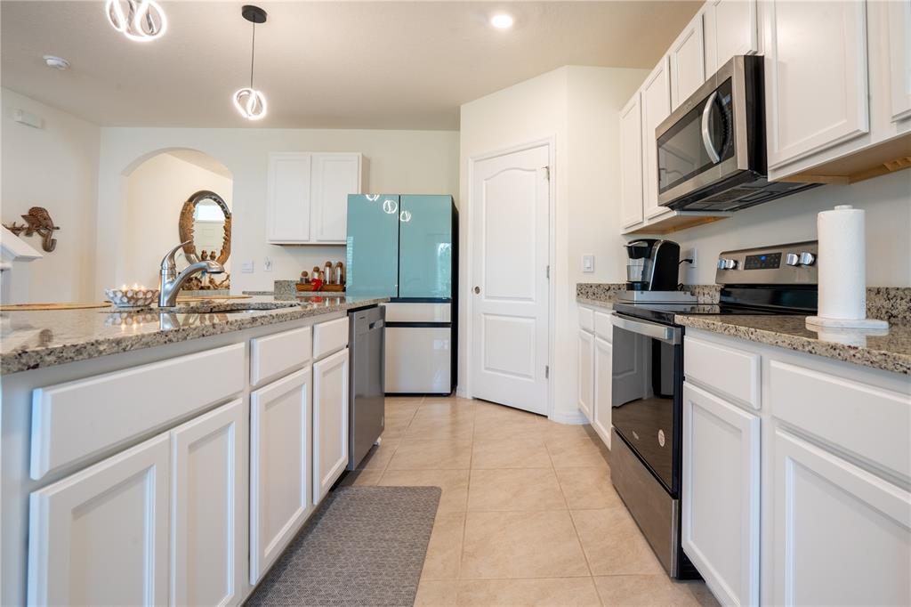 2540 Harmonia Hammock Road Harmony, FL 34773 - Photo 12 of 54 a kitchen with granite countertop a sink stainless steel appliances and cabinets