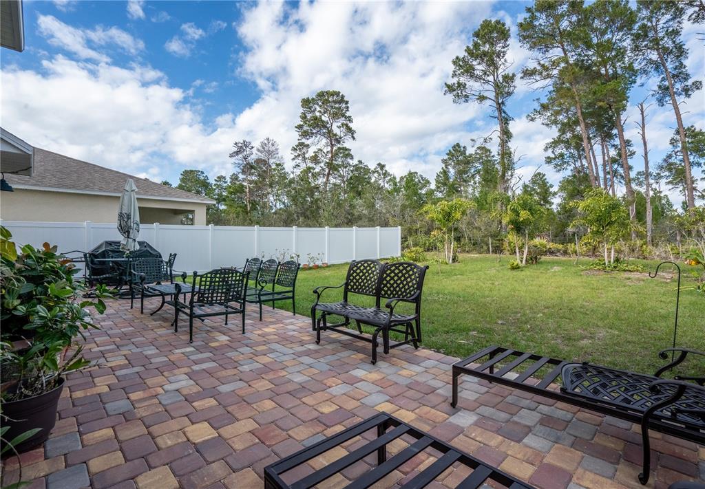2540 Harmonia Hammock Road Harmony, FL 34773 - Photo 38 of 54 a view of a backyard with chairs potted plants and a large tree