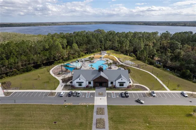 an aerial view of a house with a garden and lake view