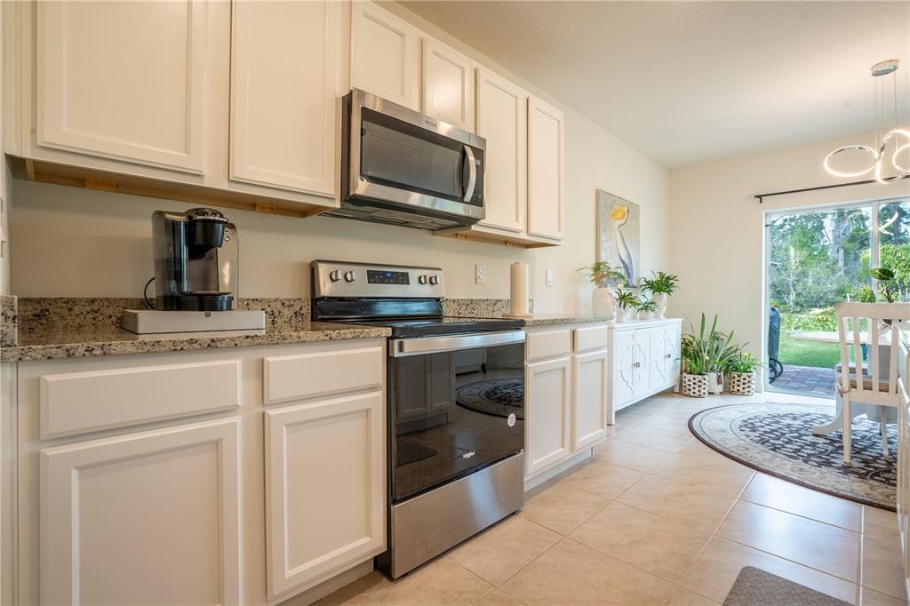 2540 Harmonia Hammock Road Harmony, FL 34773 - Photo 10 of 54 a kitchen with stainless steel appliances granite countertop a stove a sink and a microwave