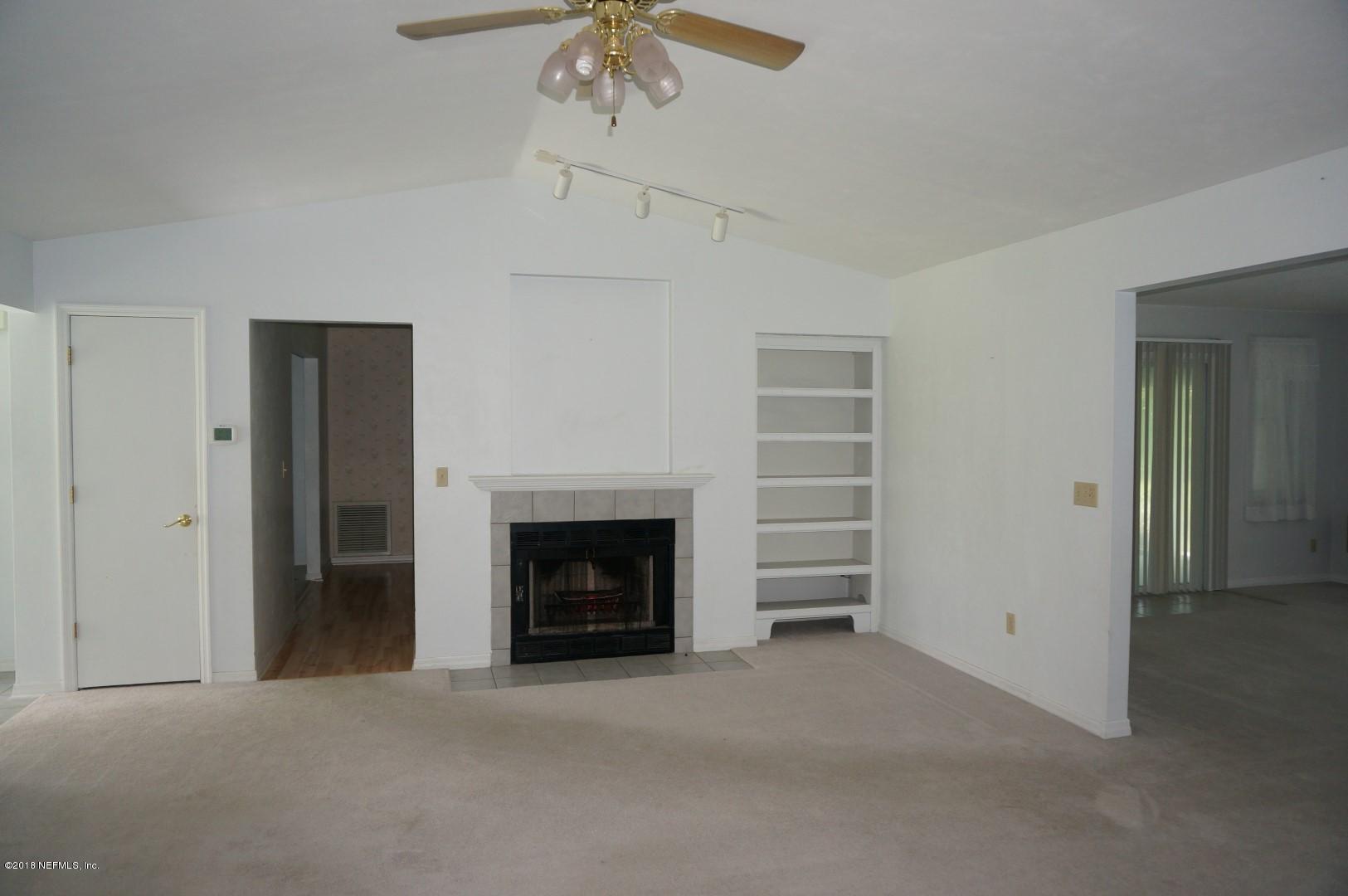 6511 Brooklyn Bay Road Keystone Heights, FL 32656 - Photo 6 of 25 an empty room with a fireplace and fan