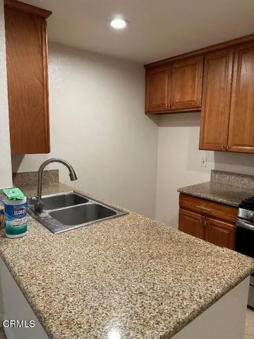 a kitchen with granite countertop wooden cabinets and a sink