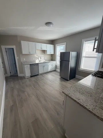 a large white kitchen with a granite countertop sink