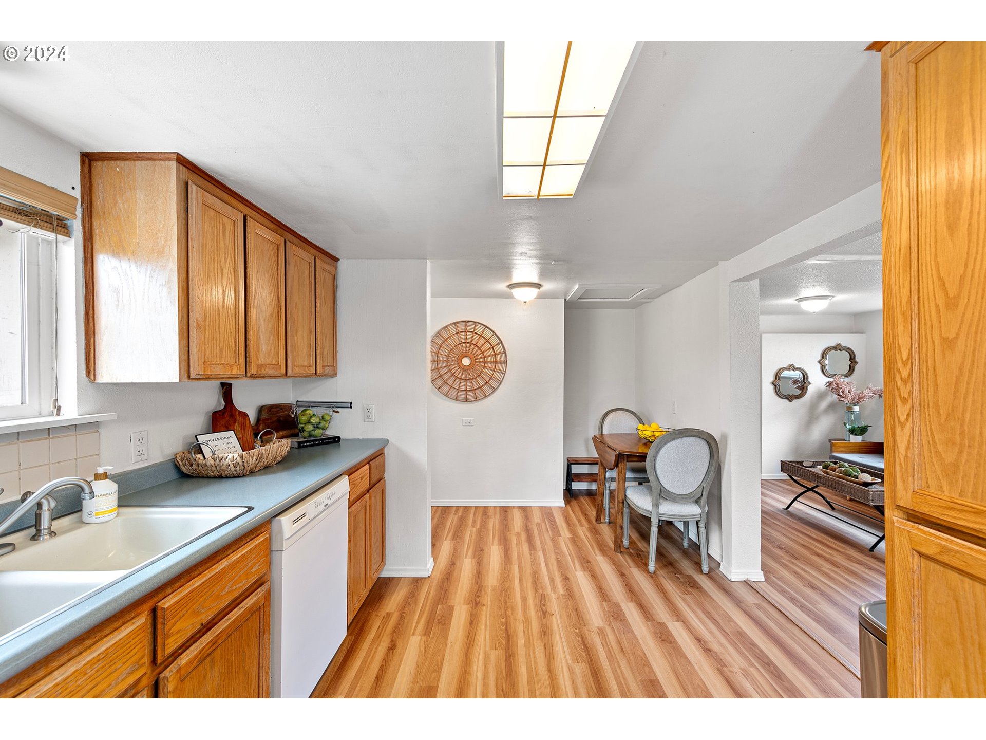 280 South 35th Street Springfield, OR 97478 - Photo 6 of 12 a open kitchen with a sink a wooden floor a clock and cabinets