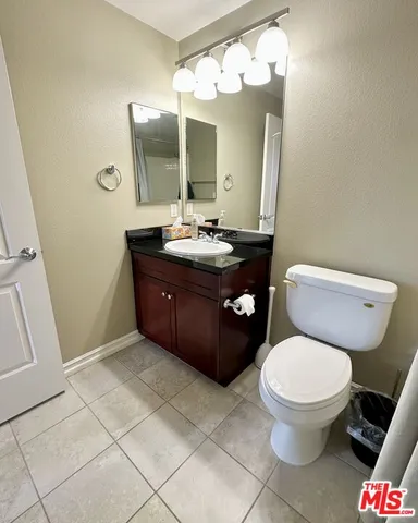 a view of an empty room with wooden floor and a ceiling fan