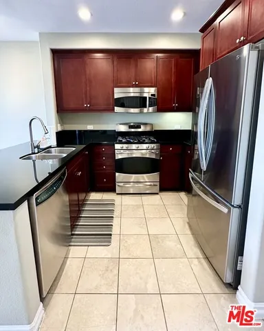 a kitchen with stainless steel appliances granite countertop a refrigerator and a stove