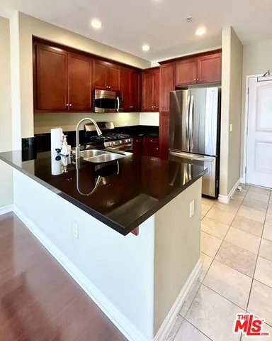 a kitchen with stainless steel appliances granite countertop a refrigerator stove top oven a sink and dishwasher
