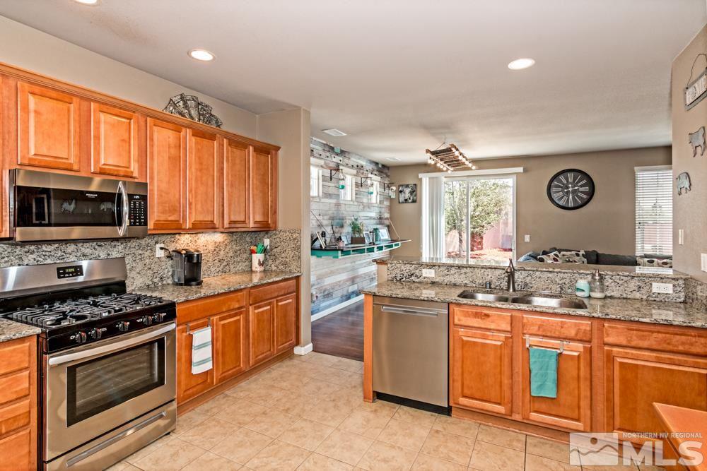 1893 Resistol Drive Reno, NV 89521 - Photo 11 of 26 a kitchen with stainless steel appliances granite countertop a stove a sink and a microwave