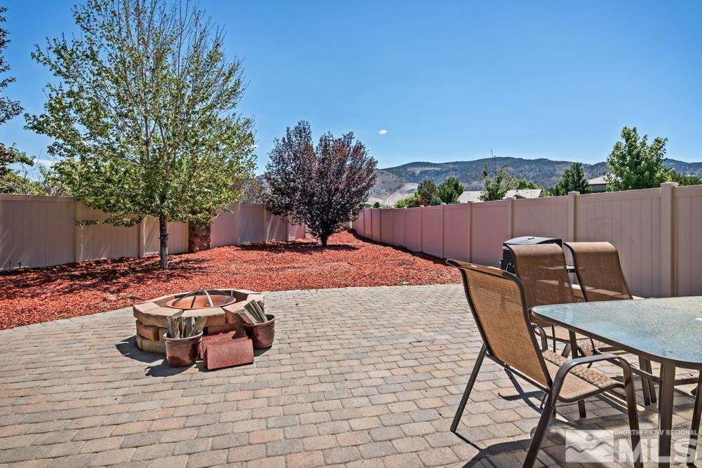 1893 Resistol Drive Reno, NV 89521 - Photo 22 of 26 a view of a backyard with table and chairs potted plants and wooden fence