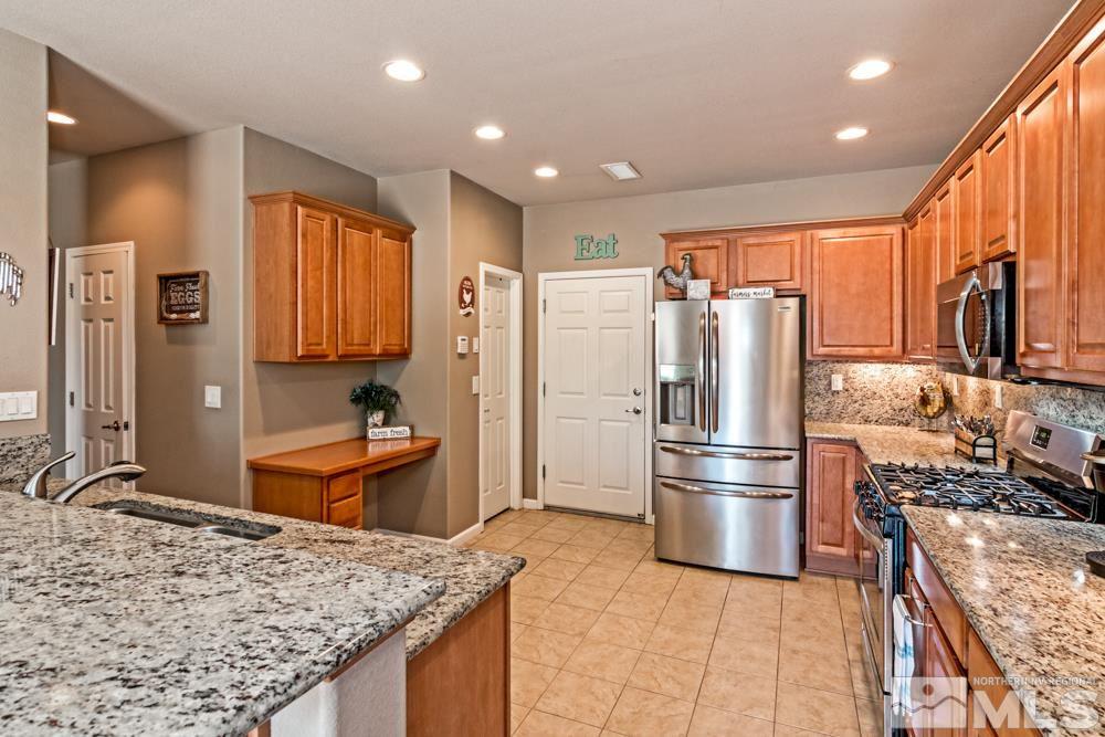 1893 Resistol Drive Reno, NV 89521 - Photo 9 of 26 a kitchen with stainless steel appliances granite countertop a refrigerator stove and sink