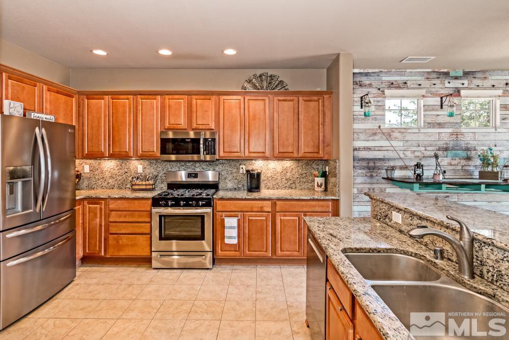 1893 Resistol Drive Reno, NV 89521 - Photo 10 of 26 a kitchen with granite countertop a stove top oven microwave and refrigerator