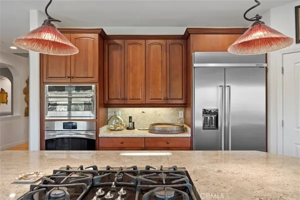 a kitchen with stainless steel appliances granite countertop a sink a stove and a wooden floors