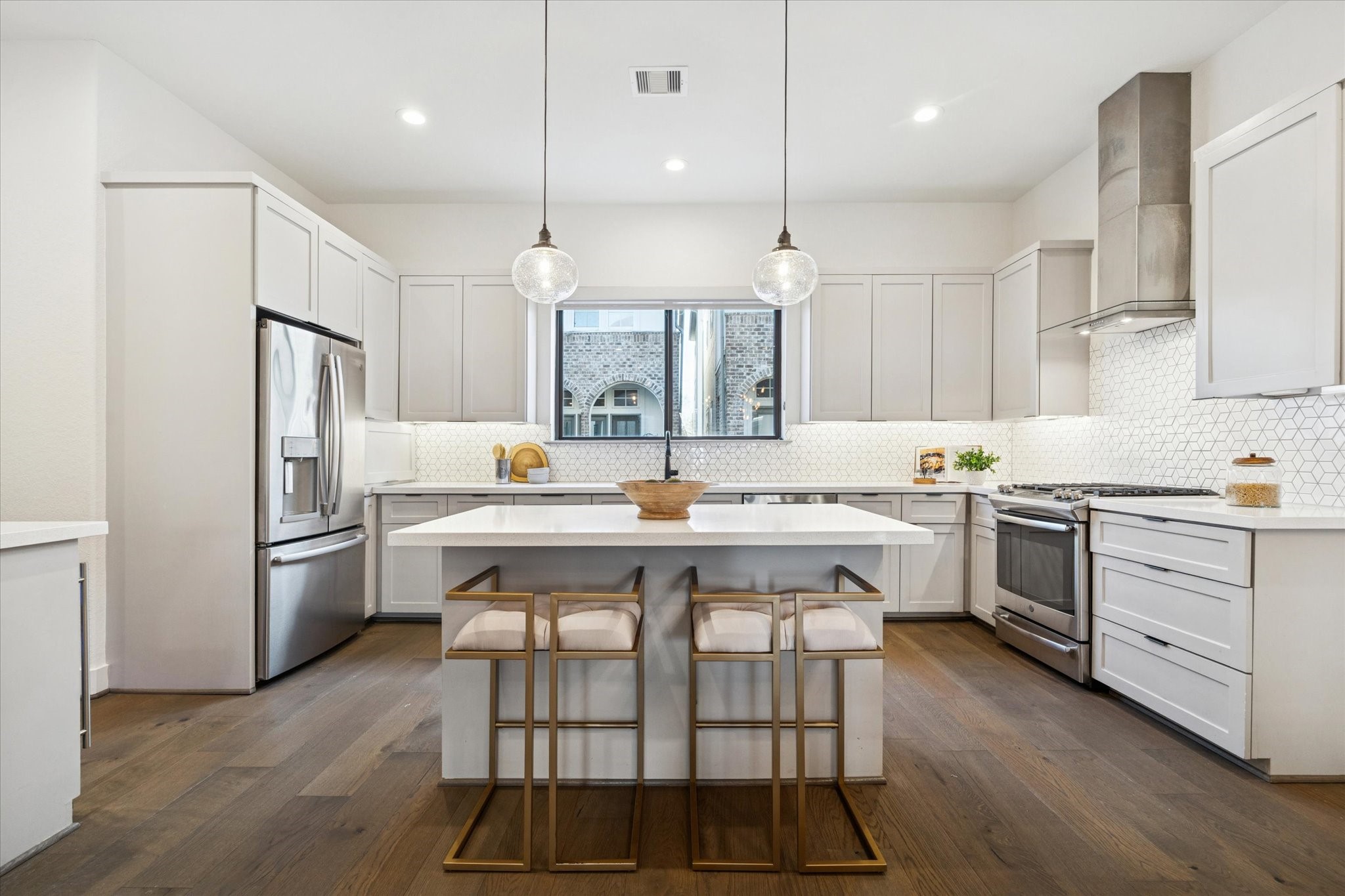 1122 Thompson Street Houston, TX 77007 - Photo 5 of 25 a kitchen with a white center island and stainless steel appliances