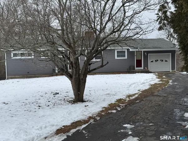 a front view of a house with a yard covered in snow