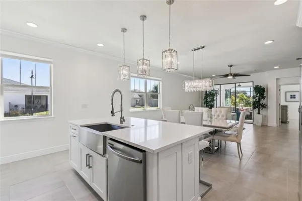 a kitchen with kitchen island a sink a counter space and living room view