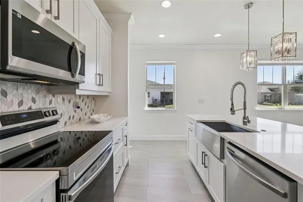 a kitchen with stainless steel appliances a sink stove and microwave