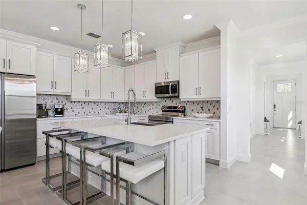 a kitchen with kitchen island granite countertop a sink cabinets and stainless steel appliances