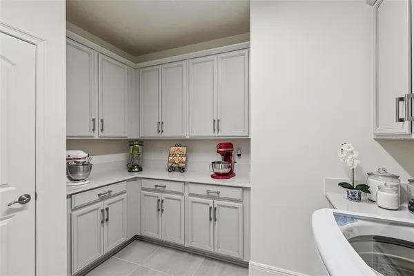 a kitchen with white cabinets and sink