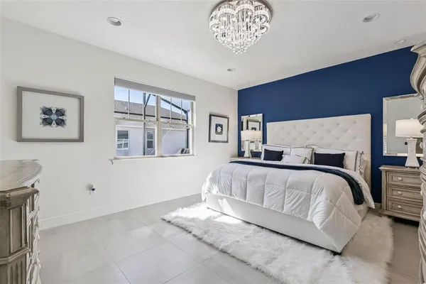 a spacious bedroom with a large bed and a chandelier