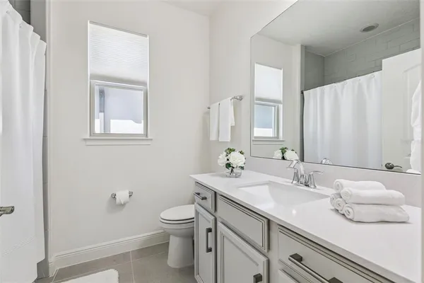 a bathroom with a sink a toilet and a mirror