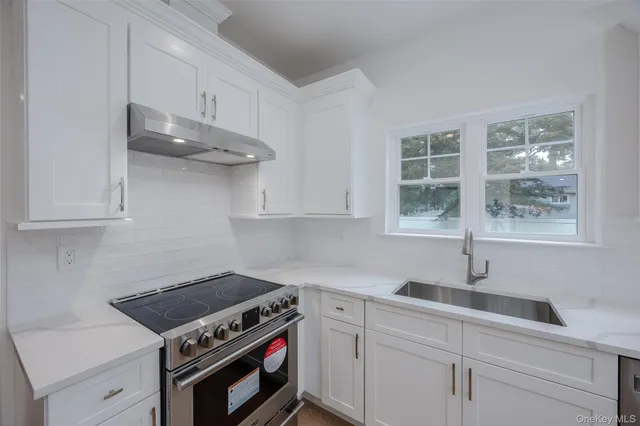 a kitchen with stainless steel appliances a stove a sink and cabinets