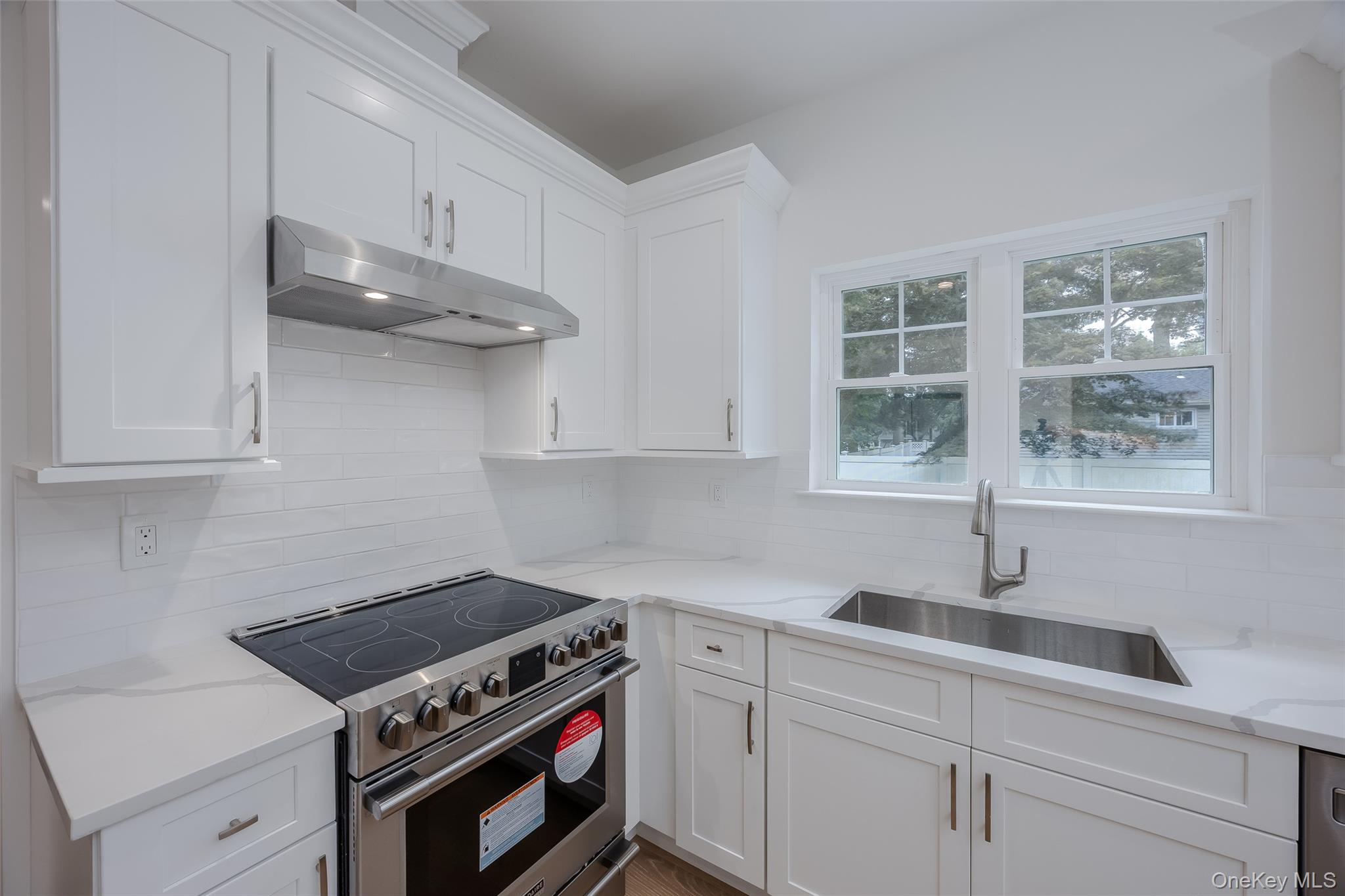 40 Zenith Road Rocky Point, NY 11778 - Photo 13 of 38 a kitchen with stainless steel appliances a stove a sink and cabinets