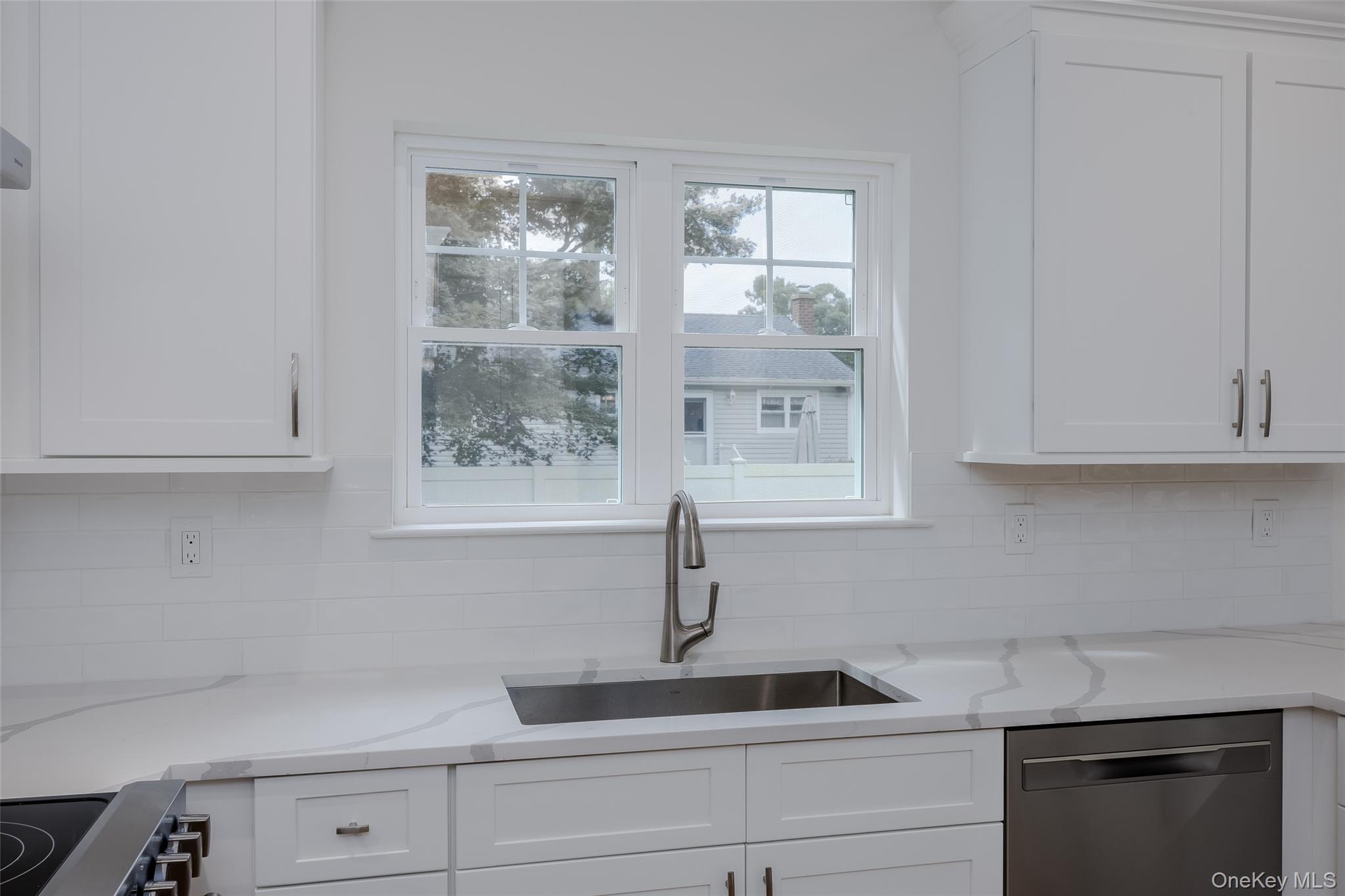 40 Zenith Road Rocky Point, NY 11778 - Photo 14 of 38 a kitchen with white cabinets and a window