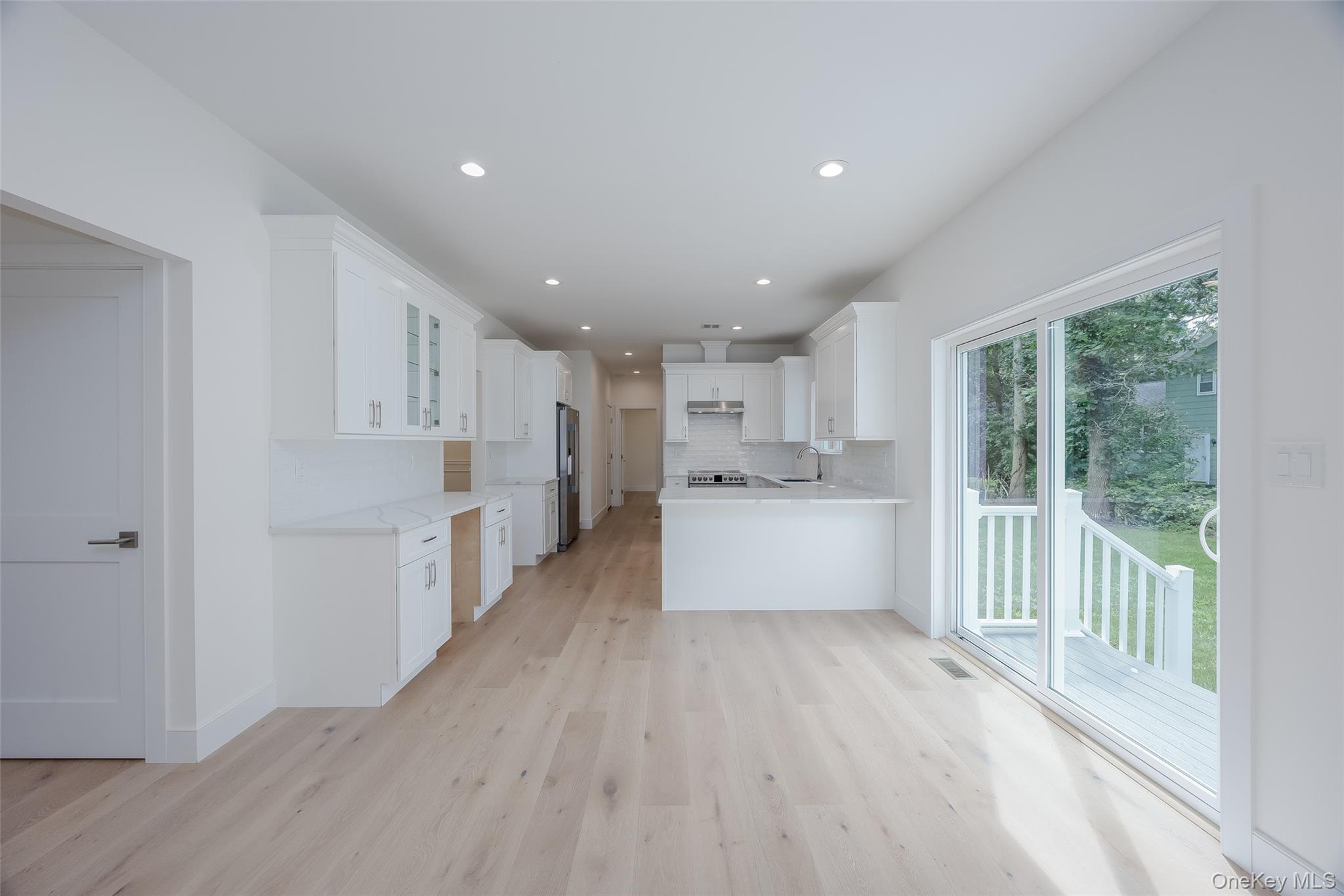 40 Zenith Road Rocky Point, NY 11778 - Photo 16 of 38 a large white kitchen with wooden floors and white walls