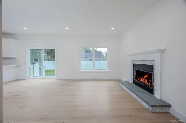 a view of an empty room with a fireplace and a window