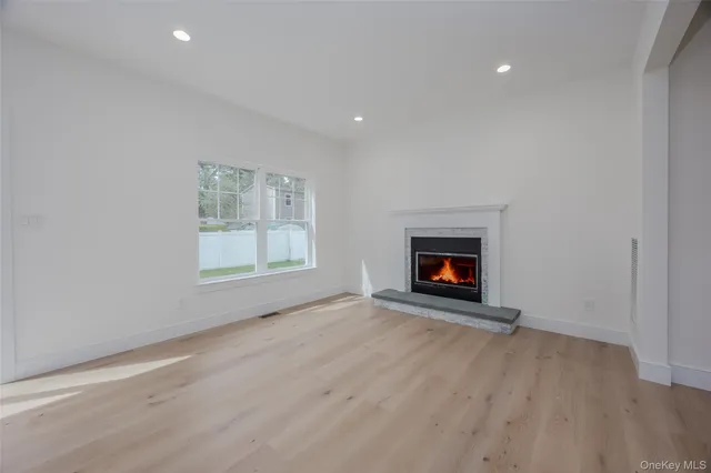a view of an empty room with a window and fireplace