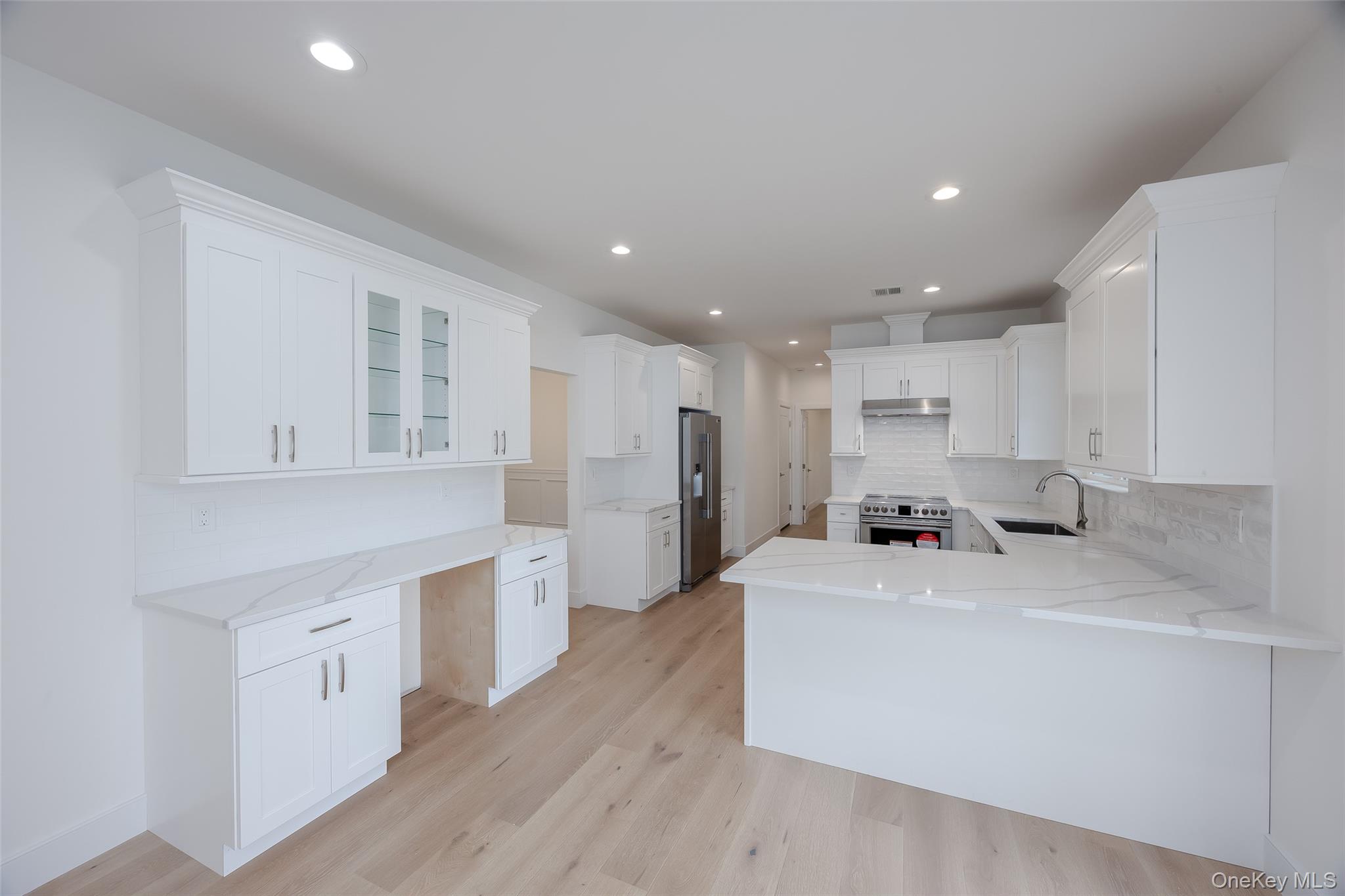 40 Zenith Road Rocky Point, NY 11778 - Photo 10 of 38 a kitchen with a sink a stove a refrigerator and white cabinets