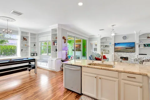 a kitchen that has a lot of cabinets a sink and appliances in it