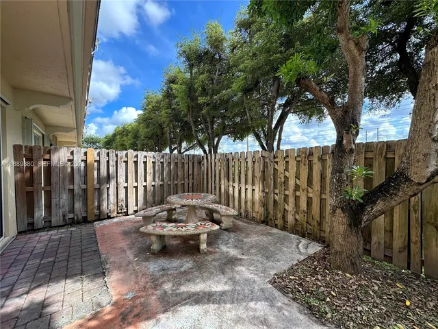 a backyard of a house with table and chairs