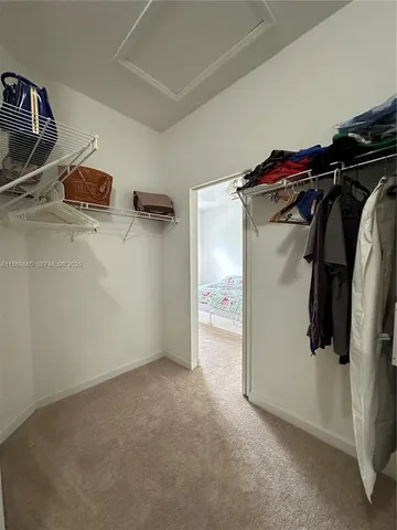 a view of walk in closet with clothes and shoes