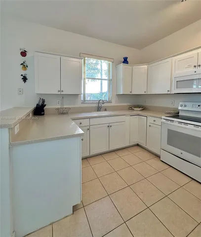 a kitchen with a sink cabinets and window