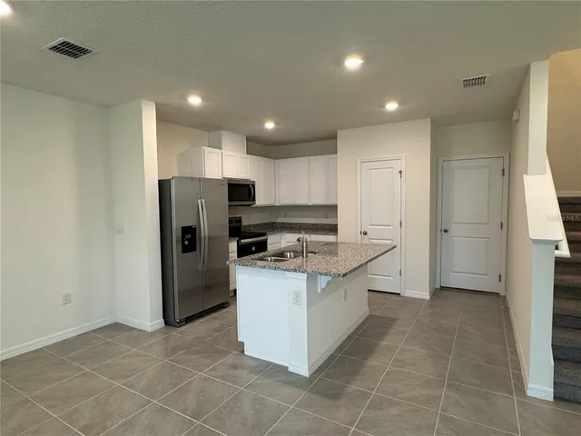 a kitchen with stainless steel appliances a refrigerator and a stove top oven