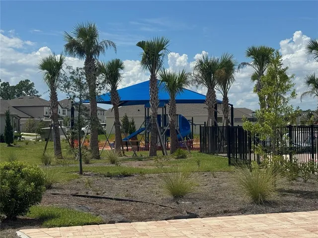 a view of house with swimming pool and yard in front of it