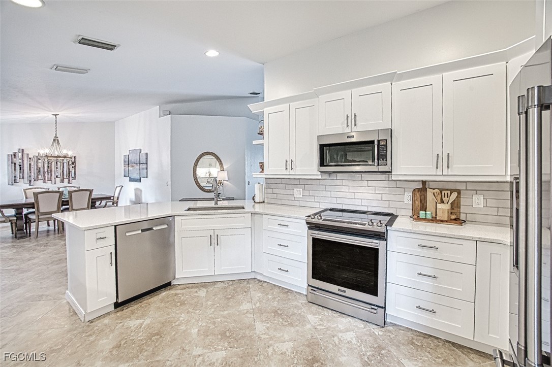9570 Hemingway Lane, Unit 3205 Fort Myers, FL 33913 - Photo 11 of 43 a kitchen with white cabinets and appliances