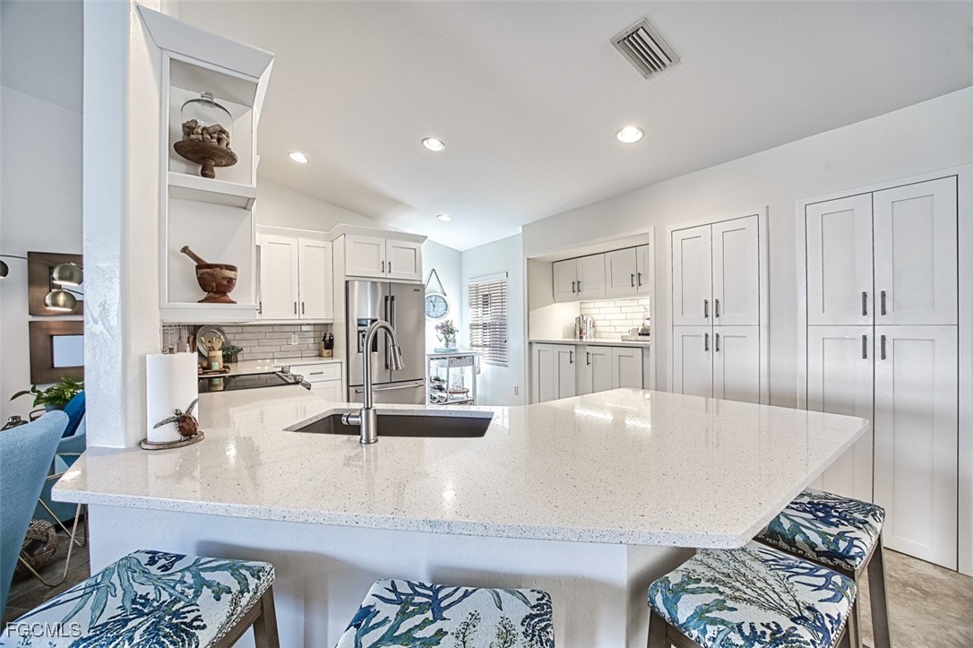 9570 Hemingway Lane, Unit 3205 Fort Myers, FL 33913 - Photo 13 of 43 a large kitchen with a large counter top appliances and cabinets
