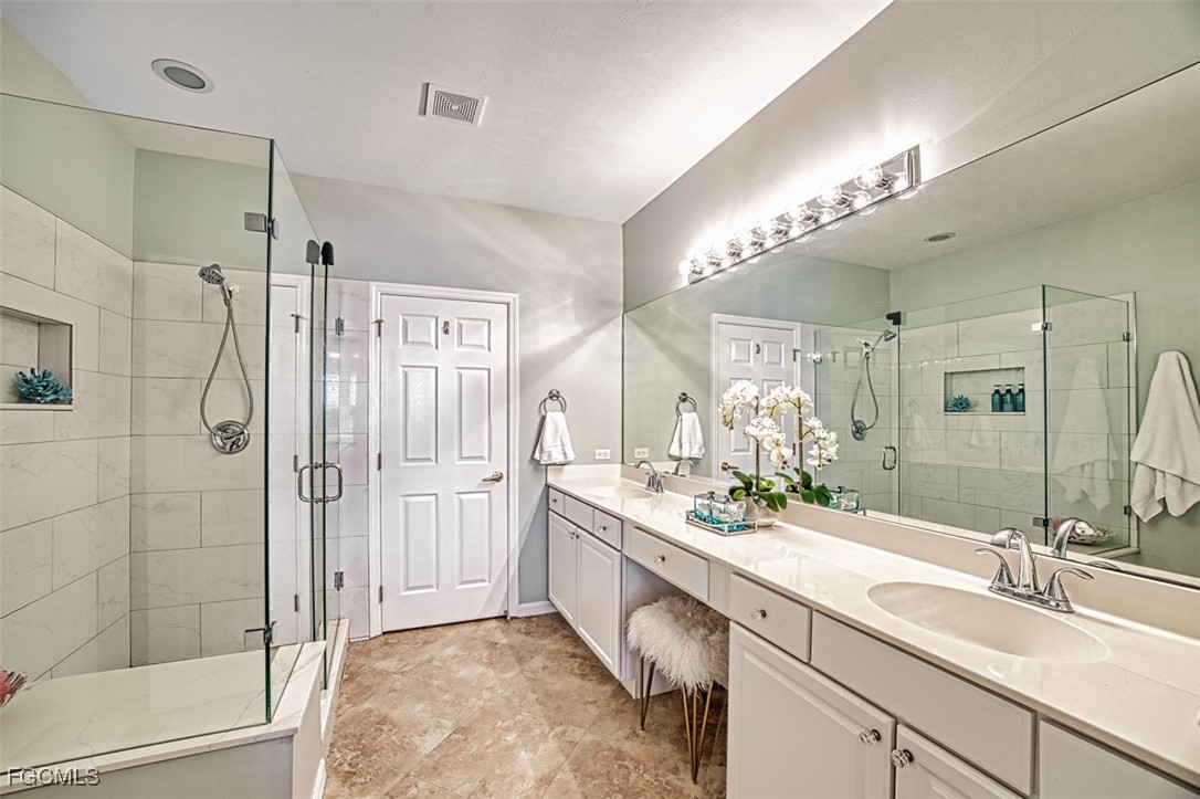9570 Hemingway Lane, Unit 3205 Fort Myers, FL 33913 - Photo 20 of 43 a spacious bathroom with a double vanity sink mirror and shower
