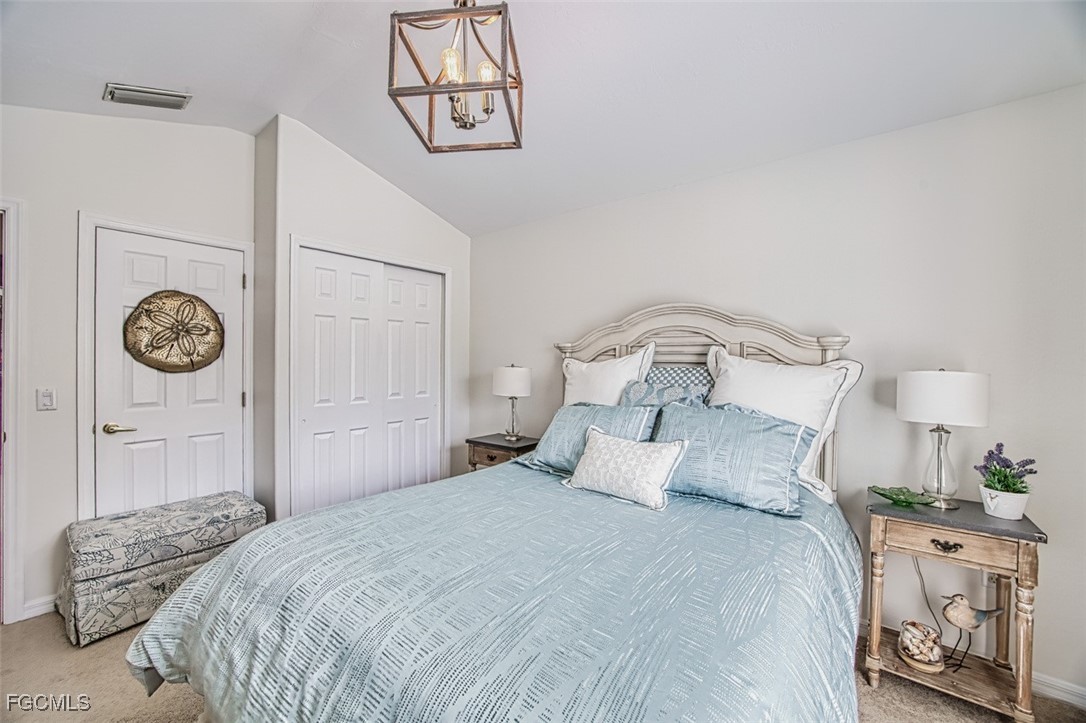 9570 Hemingway Lane, Unit 3205 Fort Myers, FL 33913 - Photo 28 of 43 a bedroom with a bed and a chandelier