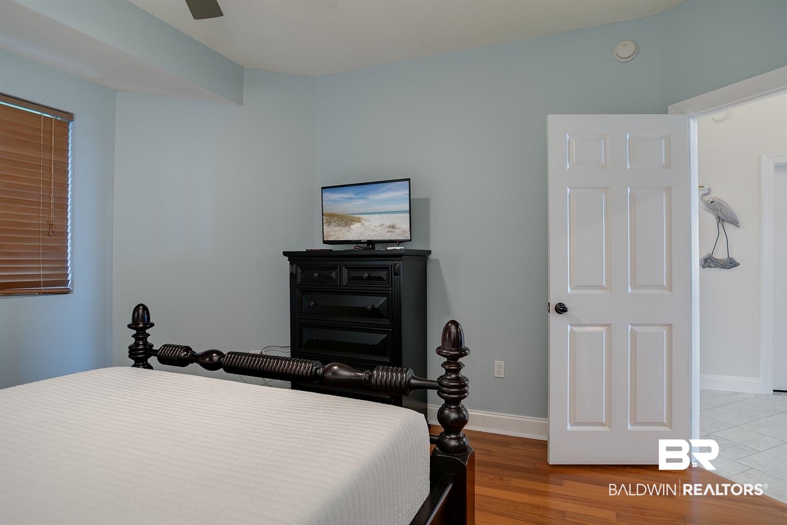 27800 Canal Road, Unit 411 Orange Beach, AL 36561 - Photo 18 of 49 Hardwood flooring throughout, featuring a window with wood blinds and a paneled interior door
