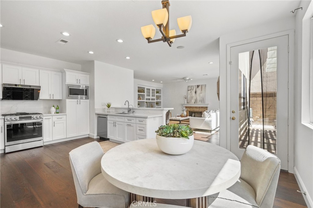 28 Rosenblum Irvine, CA 92602 - Photo 11 of 30 a view of a dining room with furniture a kitchen a chandelier a wooden table and chairs